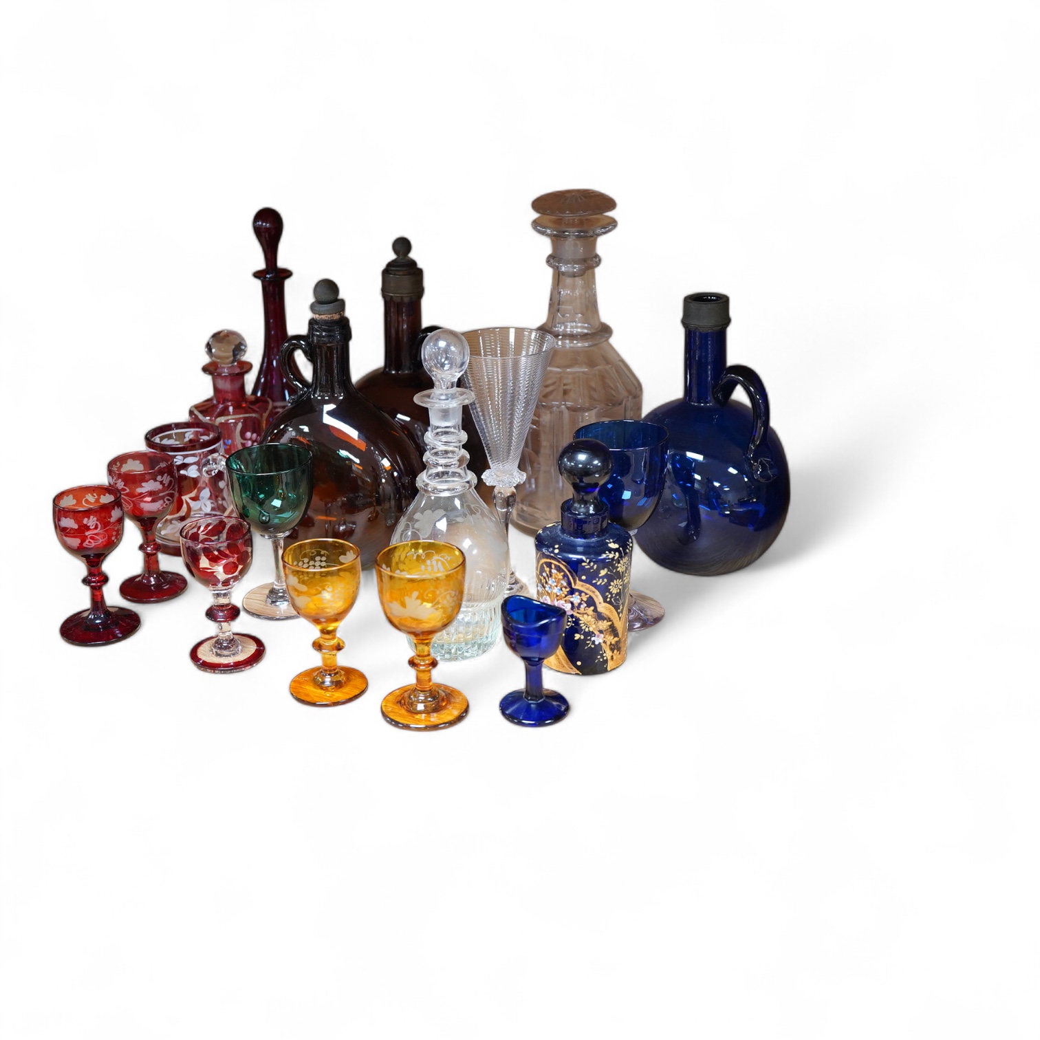 A collection of coloured glass flagons, glasses and bottles etc. (18). Tallest decanter and stopper 25cm high.